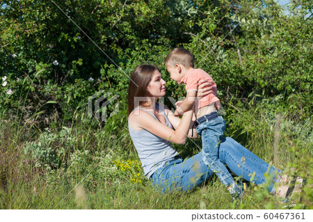Beautiful mom with her son on a picnic rest in nature Beautiful mom with her son on a picnic rest in nature 60467361