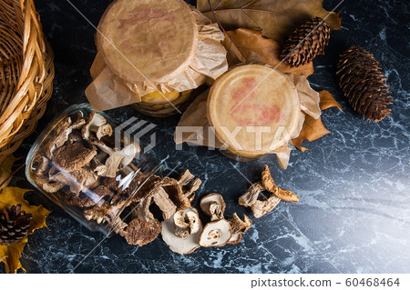 Two glass jars with wild mushrooms on black marble Two glass jars with wild mushrooms on black marble 60468464