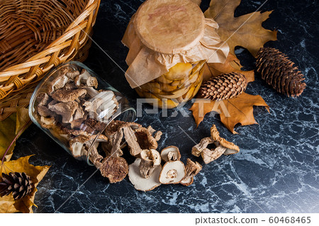 Two glass jars with wild mushrooms on black marble Two glass jars with wild mushrooms on black marble 60468465