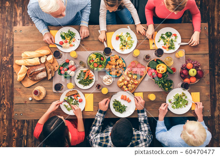 Parents and young couple sit and eating Parents and young couple sit and eating 60470477