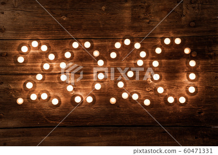 2020 new year concept with tealight candles on wooden background 60471331