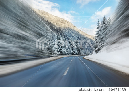 Winter alpine road curve landscape with forest, mountains and blue sky on background at bright cold sunny day. Car trip family travel journey. Holiday skiing vacation. scenic austrian landscape Winter alpine road curve landscape with forest, mountains and blue sky on background at bright cold sunny day. Car trip family travel journey. Holiday skiing vacation. scenic austrian landscape 60471489