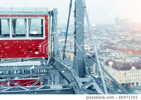 aerial panoramic citiscape view of Vienna from top of Prater amusement fair park ferris wheel during snowfall on cold snowy day. Winter Vienna holiday travel background 60471591