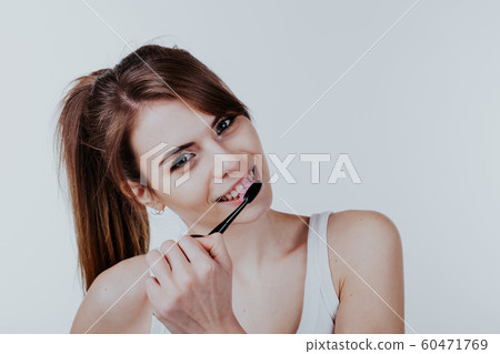 pretty girl in the bathroom brushing his teeth smile 60471769