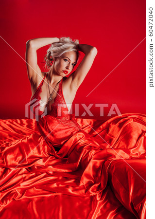 sexy blonde woman in red underwear lies on the bed 60472040