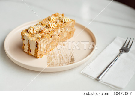 Coffee cake. A piece of cake on a plate. Sweet dessert on a round pink with a plate wooden background. Close-up Coffee cake. A piece of cake on a plate. Sweet dessert on a round pink with a plate wooden background. Close-up 60472067
