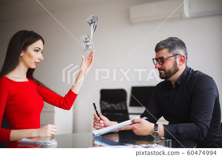 Business Woman Gives Money to Men. Woman Dressed in Red Dress Gives Bribe. Business Man In Gray Jacket Gets Bribe. High Resolution 60474994