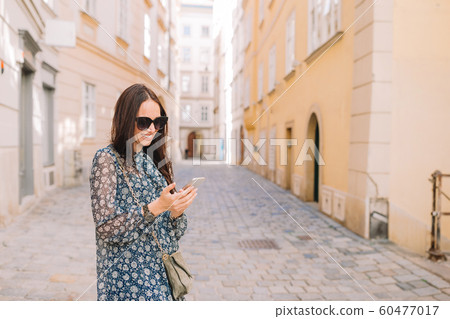 Woman talk by her smartphone in city. Young attractive tourist outdoors in italian city 60477017