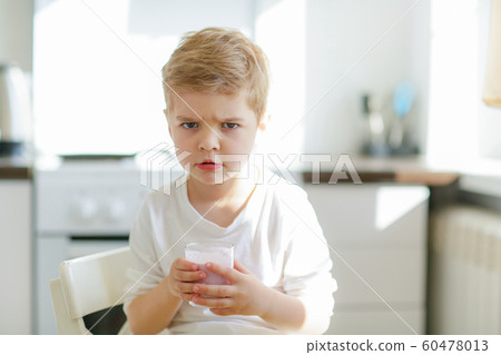 Kid or blonde happy boy eating at table. Childhood and happiness, independence. Breakfast, morning, family. Small boy child eat banana and drink milk. Healthy food and vitamin. dieting, vegetarian Kid or blonde happy boy eating at table. Childhood and happiness, independence. Breakfast, morning, family. Small boy child eat banana and drink milk. Healthy food and vitamin. dieting, vegetarian 60478013
