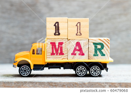 Truck hold letter block in word 11mar on wood background  60479068