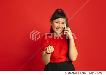 Asian teenager's portrait isolated on red studio background 60479289