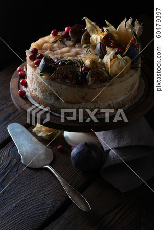 Cheesecake with dates and physalis on a stand with a napkin and a spoon 60479397