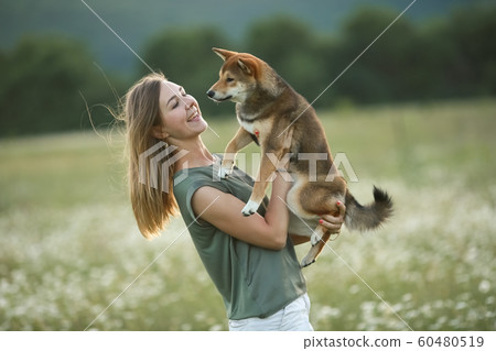 A young woman hugs her beloved pet dog 60480519