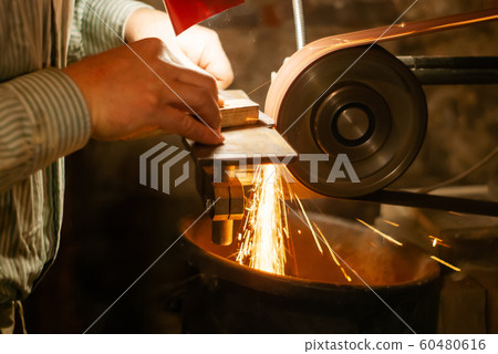 locksmith hands grind the workpiece 60480616