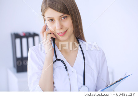 Clinic. Medical physician female doctor over clinic interior background. 60482127