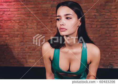 A portrait of a sporty young woman posing over the brick wall. Beauty, health, sport. A portrait of a sporty young woman posing over the brick wall. Beauty, health, sport. 60483206