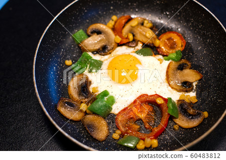 Freshly fried eggs with vegetables in a pan Freshly fried eggs with vegetables in a pan 60483812
