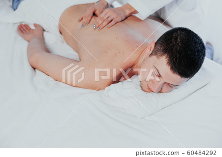 a massage therapist makes a man massage spa treatment health 60484292