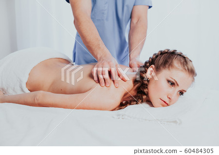 beautiful girl massage therapist makes a back massage in the spa health 60484305