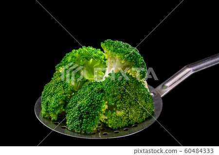 Fresh broccoli on a spoon scoop, ready for use by vegetarians 60484333