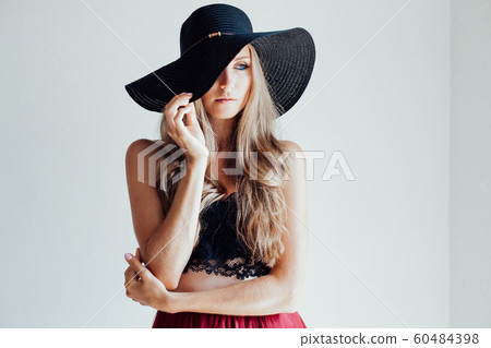 blonde girl with blue eyes a hat with a brim on a white background 60484398