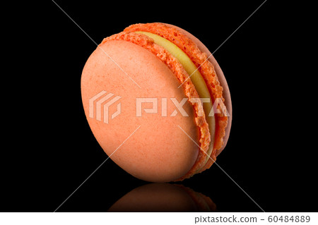 Macro photo of french orange rose macaroon with reflection isolated on black 60484889