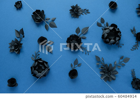 Black paper flowers on blue background. Cut from 60484914