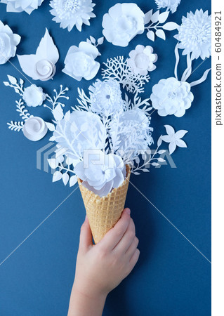 Hand holds a waffle cone with paper flowers on Hand holds a waffle cone with paper flowers on 60484921