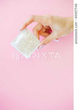 Contraception. Birth Control Pills and an unwrapped Condom. Colored Pills And Capsule On Pink Background. Pharmacy Theme, Capsule Pills With Medicine Antibiotic in Packages 60487546