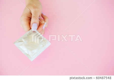 Contraception. Birth Control Pills and an unwrapped Condom. Colored Pills And Capsule On Pink Background. Pharmacy Theme, Capsule Pills With Medicine Antibiotic in Packages 60487548