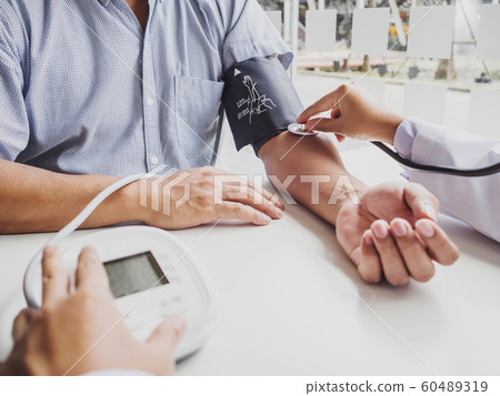 The doctor evaluates the patient with a stethoscope and records the results 60489319