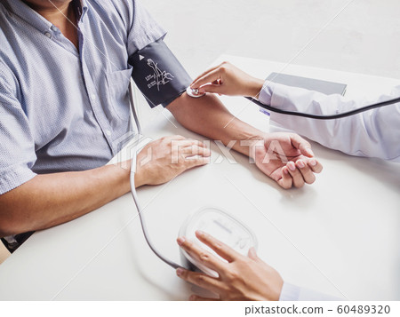 The doctor evaluates the patient with a stethoscope and records the results 60489320