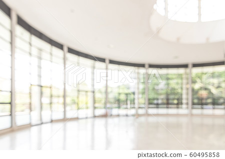 Blur background interior view looking out toward to empty office lobby and entrance doors and glass curtain wall 60495858
