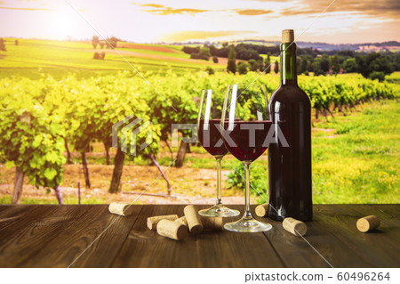 Bottle of wine and glasses on the background of the vineyard at sunset Bottle of wine and glasses on the background of the vineyard at sunset 60496264