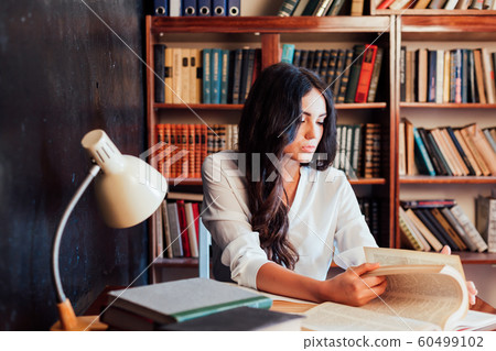 girl is preparing for the exam reading book at the library girl is preparing for the exam reading book at the library 60499102