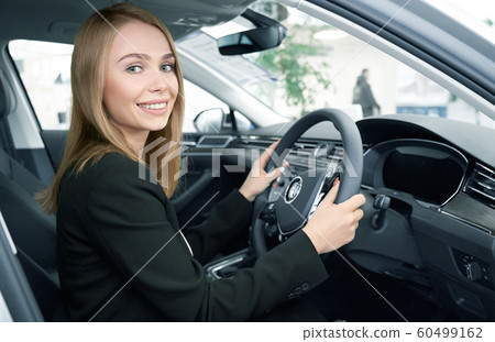 Happy female client sitting in new comfortable automobile Happy female client sitting in new comfortable automobile 60499162
