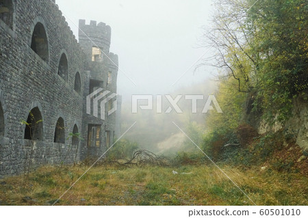 Medieval castle and fort with arch windows in misty and foggy morning on a hill. Medieval castle and fort with arch windows in misty and foggy morning on a hill. 60501010