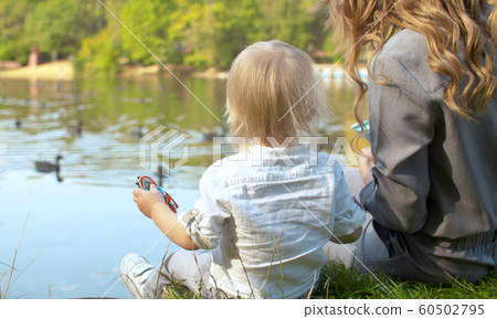 A young mother and her toddler are feeding the A young mother and her toddler are feeding the 60502795