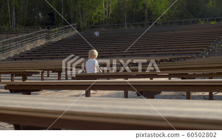 Boy walking between the benches 60502802