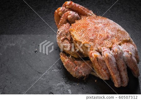 Icy hairy crab laying on the black table and slate 60507312