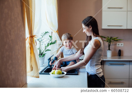 kitchen mom son wash fruits and vegetables kitchen mom son wash fruits and vegetables 60508722