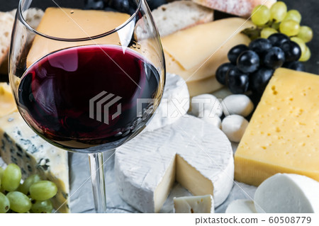 glass of red wine on the background of assorted cheeses glass of red wine on the background of assorted cheeses 60508779