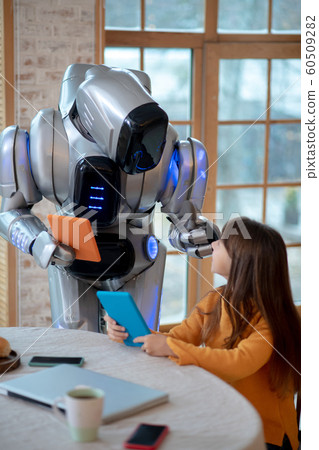 Robot with tablet in his hand discussing something with a girl Robot with tablet in his hand discussing something with a girl 60509282