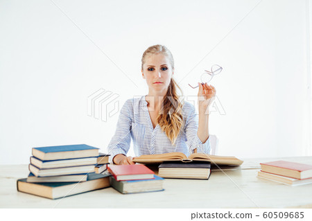 female teacher sitting at a table of many books Office 60509685