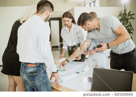 Team of young people working with diagrams at table 60509989