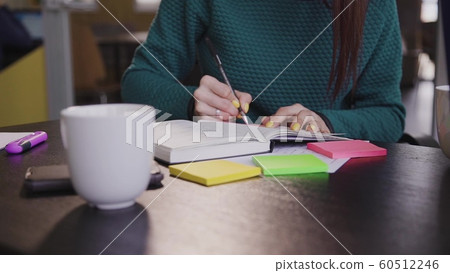 Phone on desk. Young brunette businesswoman work in office table. 60512246