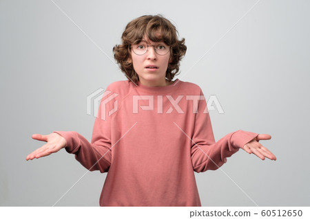 Attractive curly woman shrugging her shoulders. I do not know how it happened. Attractive curly woman shrugging her shoulders. I do not know how it happened. 60512650