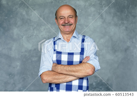 Pensive grandfather with crossed hands looking at camera. 60513543