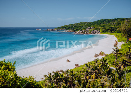 Grand Anse beach at La Digue island in Seychelles from view point above. White sandy beach with blue ocean lagoon and granite boulders Grand Anse beach at La Digue island in Seychelles from view point above. White sandy beach with blue ocean lagoon and granite boulders 60514731