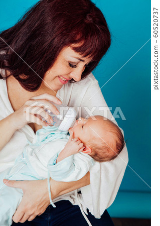 mom is feeding the baby milk from a bottle mom is feeding the baby milk from a bottle 60520737